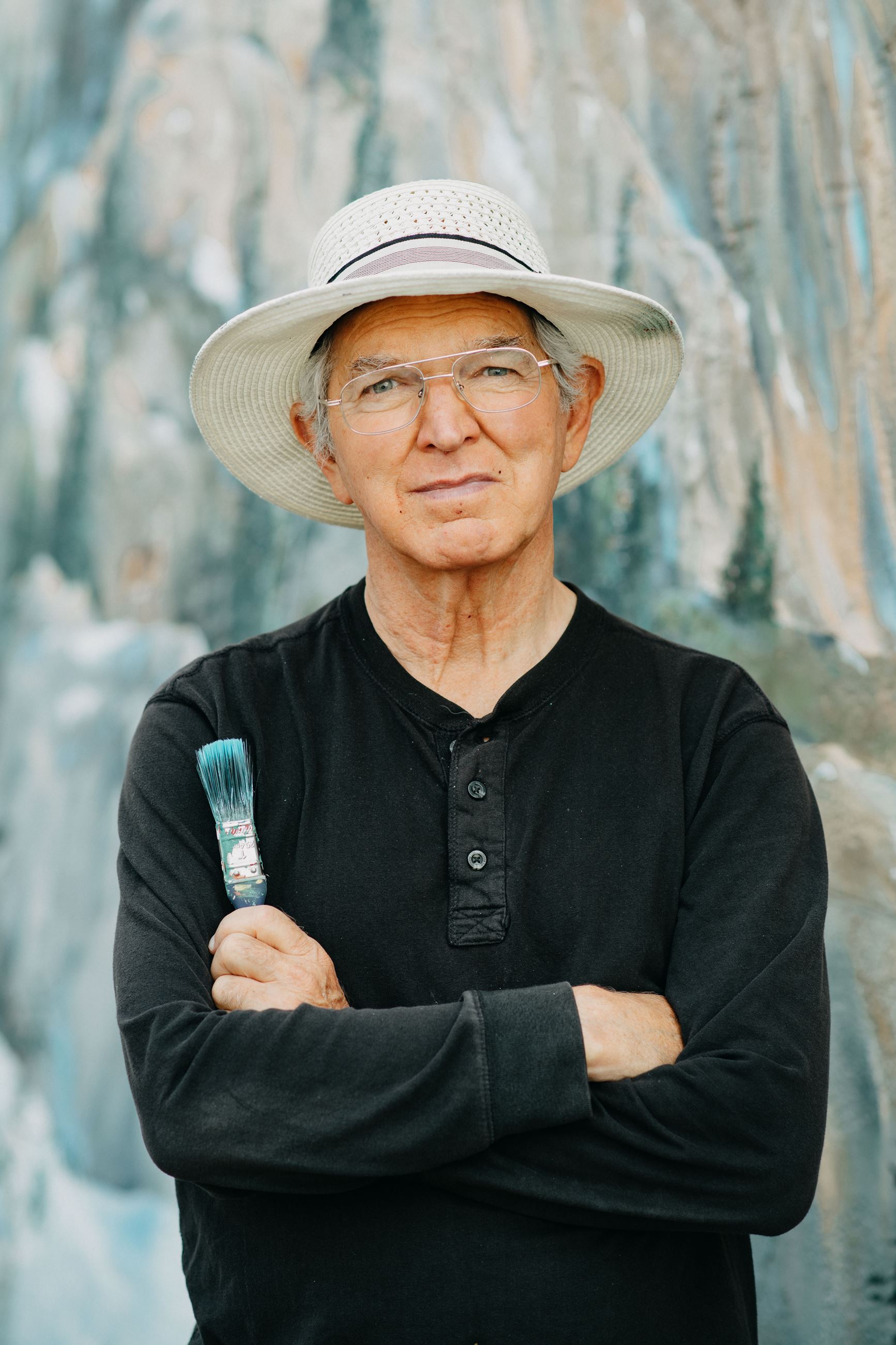 A photo of David Hose in front on his mural at Keg N Cue.